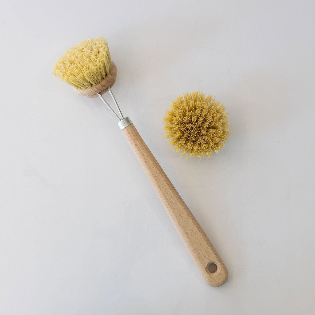 Beechwood and natural fiber dish brush with a replaceable brush head. Extra brush head next to handle.