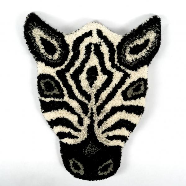 Hand-tufted wool rug shaped like a striped zebra head laying flat on a white background. A beautifully crafted and detailed zebra face.