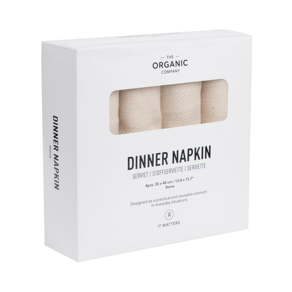 Set of four herringbone weave light tan dinner napkins in a labeled box on a white background.