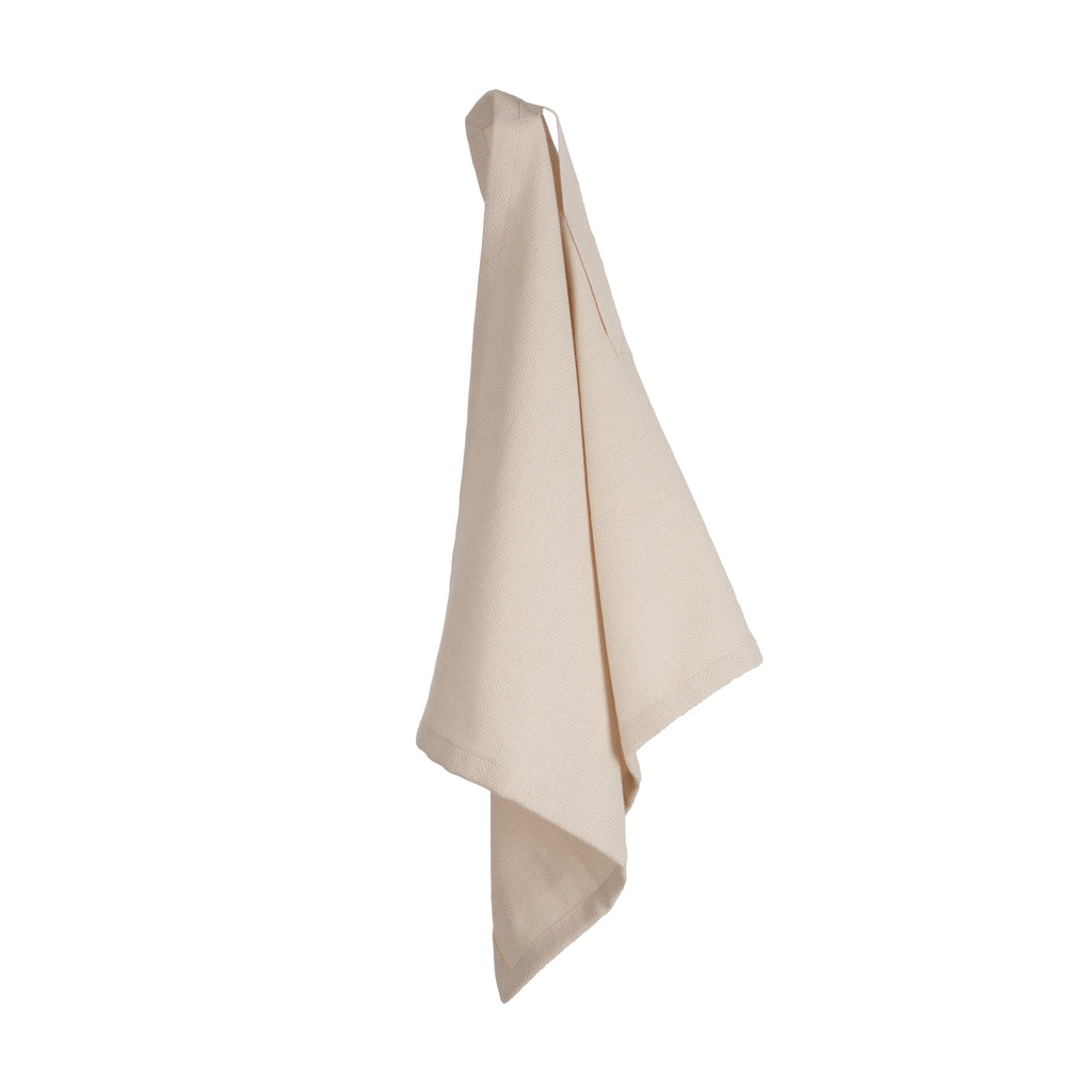 Hanging herringbone weave light tan dinner napkin on a white background.