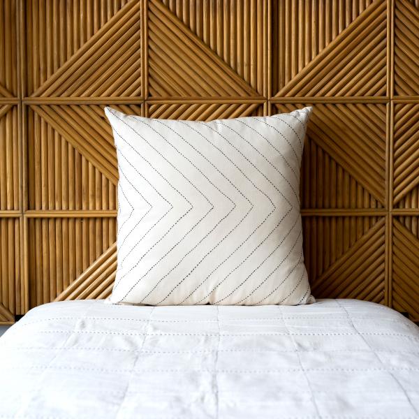 Organic cotton white pillow with contrasting black embroidery in a large arrow pattern.