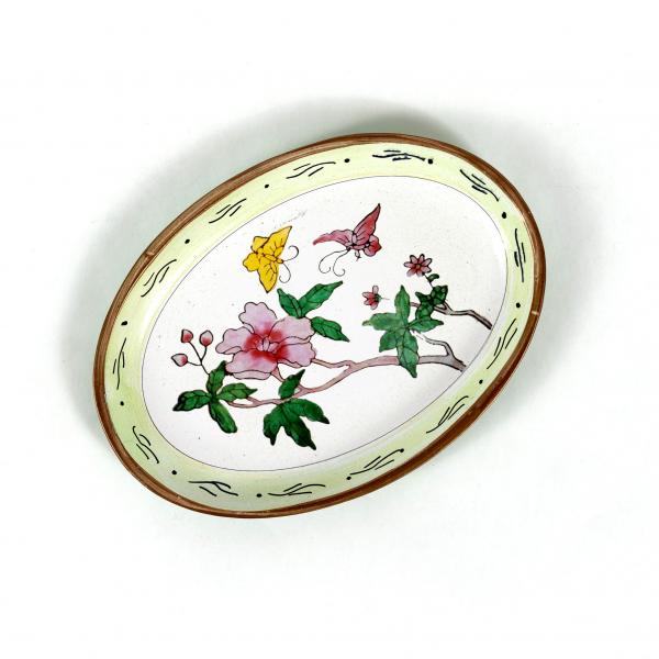 Aluminum oval trinket plate with a hand-painted depiction of wildflowers, butterflies, and leaves. Gold edge with a wispy vine repeat edge pale green border.
