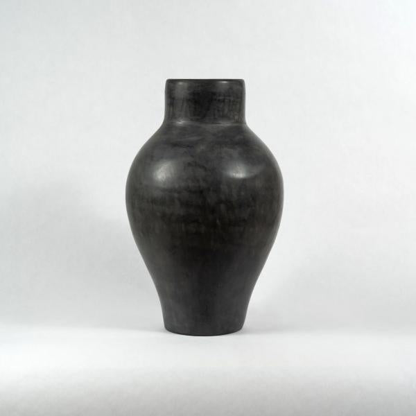 One large dark gray Tadelakt vase with a large belly that tapers to a smaller neck. White background.
