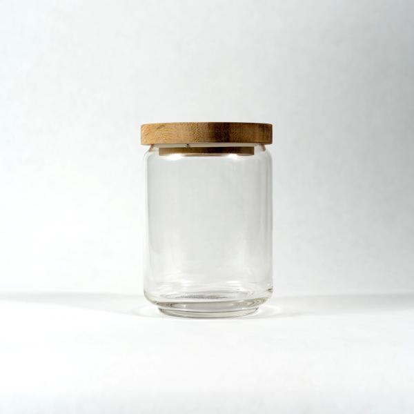Medium size of glass jar with acacia wood lid sitting in front of a white background.