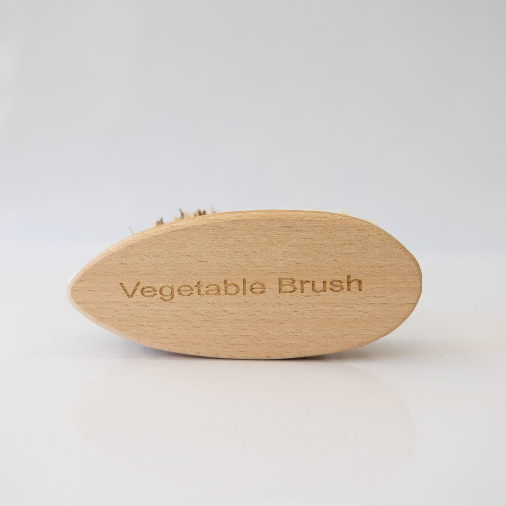 Vegetable brush handmade from plant fibers and beechwood. Back of the brush says 'Vegetable Brush'.