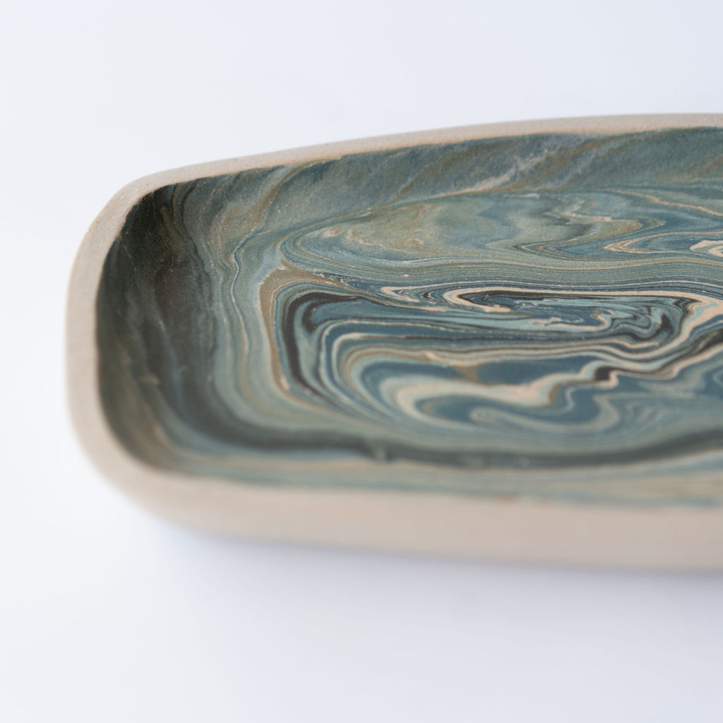 Close up of blue and tan marbled rectangular plate with a slightly raised edge.