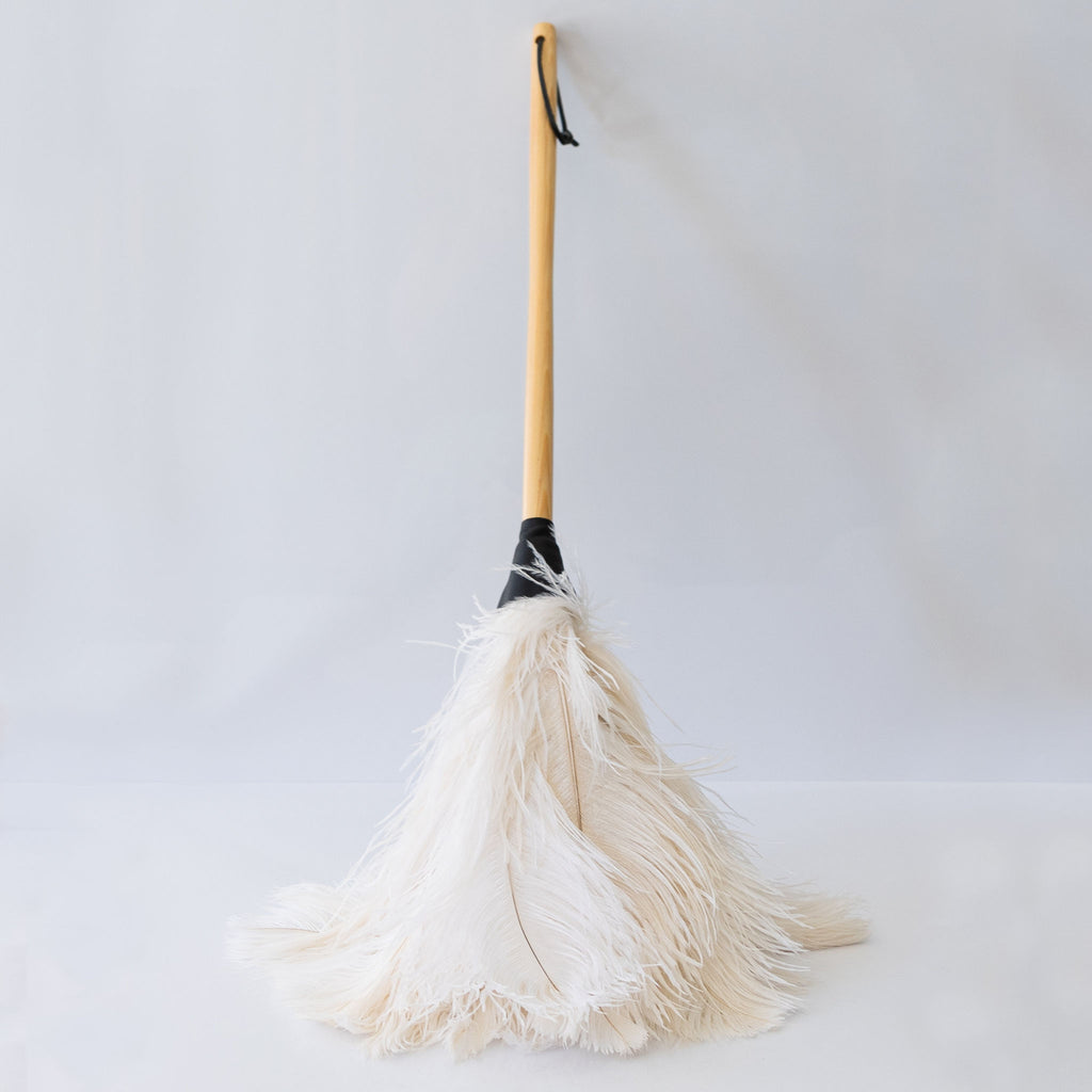 Feather duster with premium cream feathers attached to a light wood handle. Leather hanging strap.