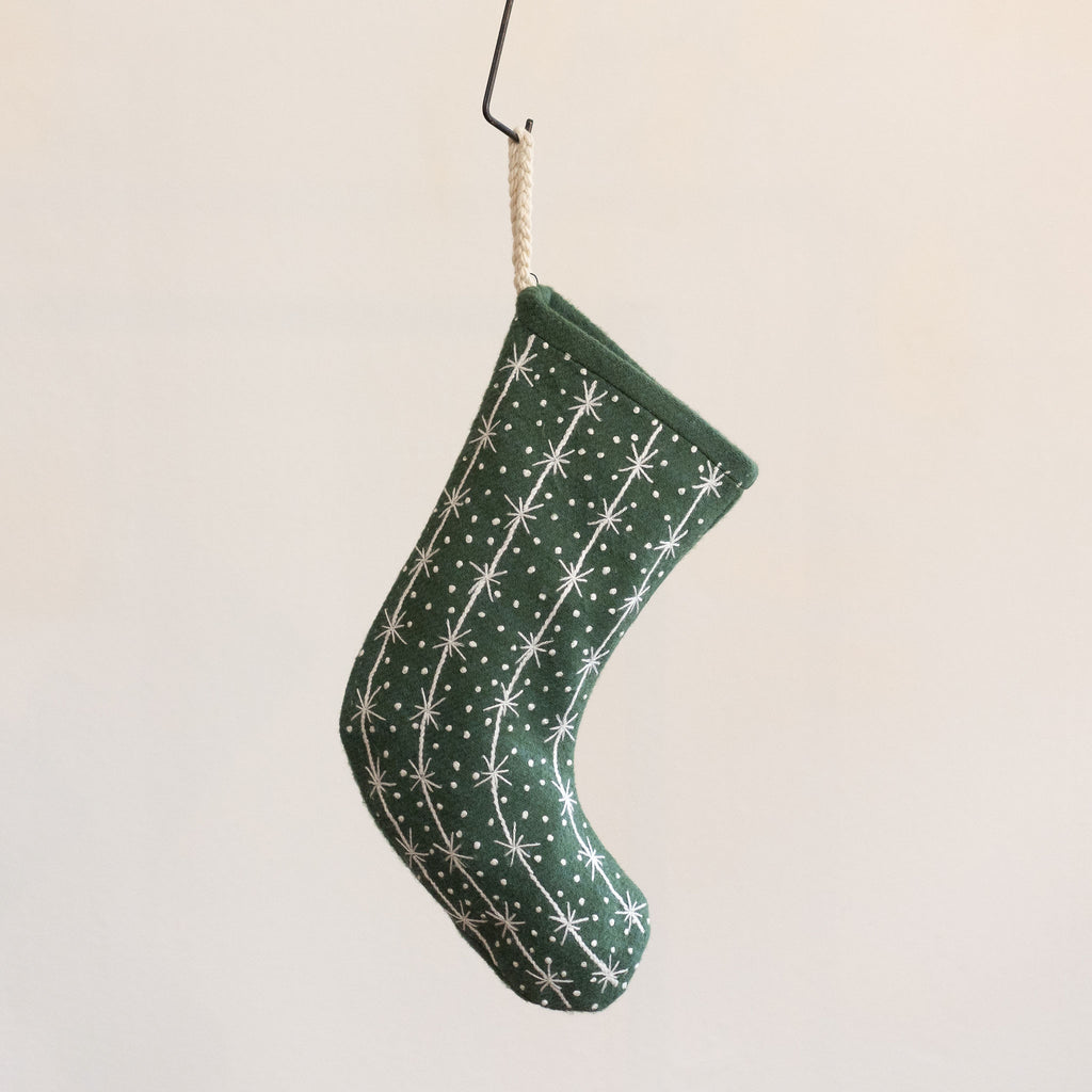 Green wool stocking with embroidered cream snowflake and polka dot design. Hangs from cream braided hanging loop. 