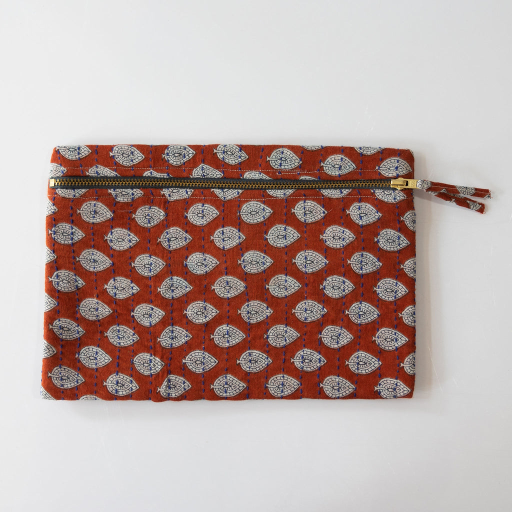  A zipper pouch clutch that is handmade and embroidered with the traditional Kantha stitch over recycled sari fabric in red and cream paisley inspired pattern. White background.
