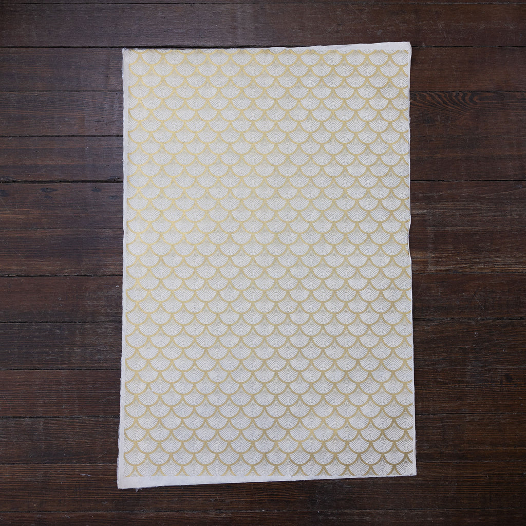 Handmade and printed paper gift wrap. Pattern is repeat Gold scallops on cream background.