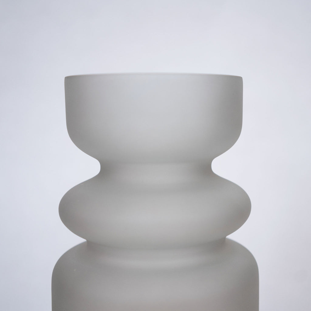 Handblown matte gray colored glass vase with 3 curvy sections. Close up.