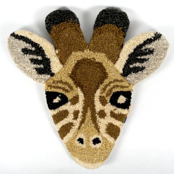 Hand-tufted wool rug shaped like a giraffe head laying flat on a white background. A beautifully crafted and detailed giraffe face.