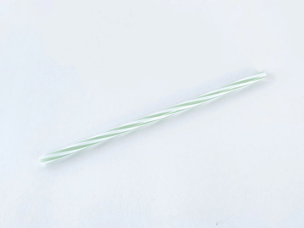 Glass straw twisted with clear and mint colors on a white background.