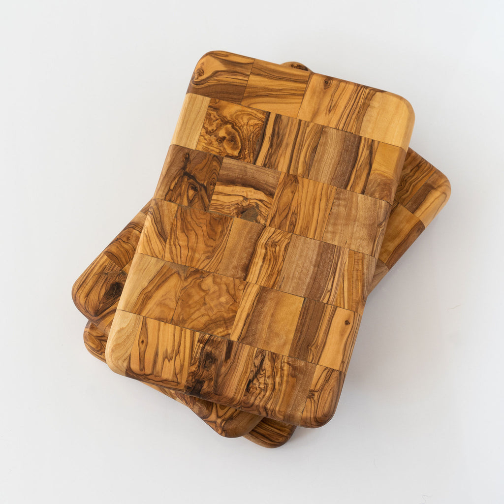 Offset stack of rectangle olive wood mosaic boards with rounded corners on a white background.