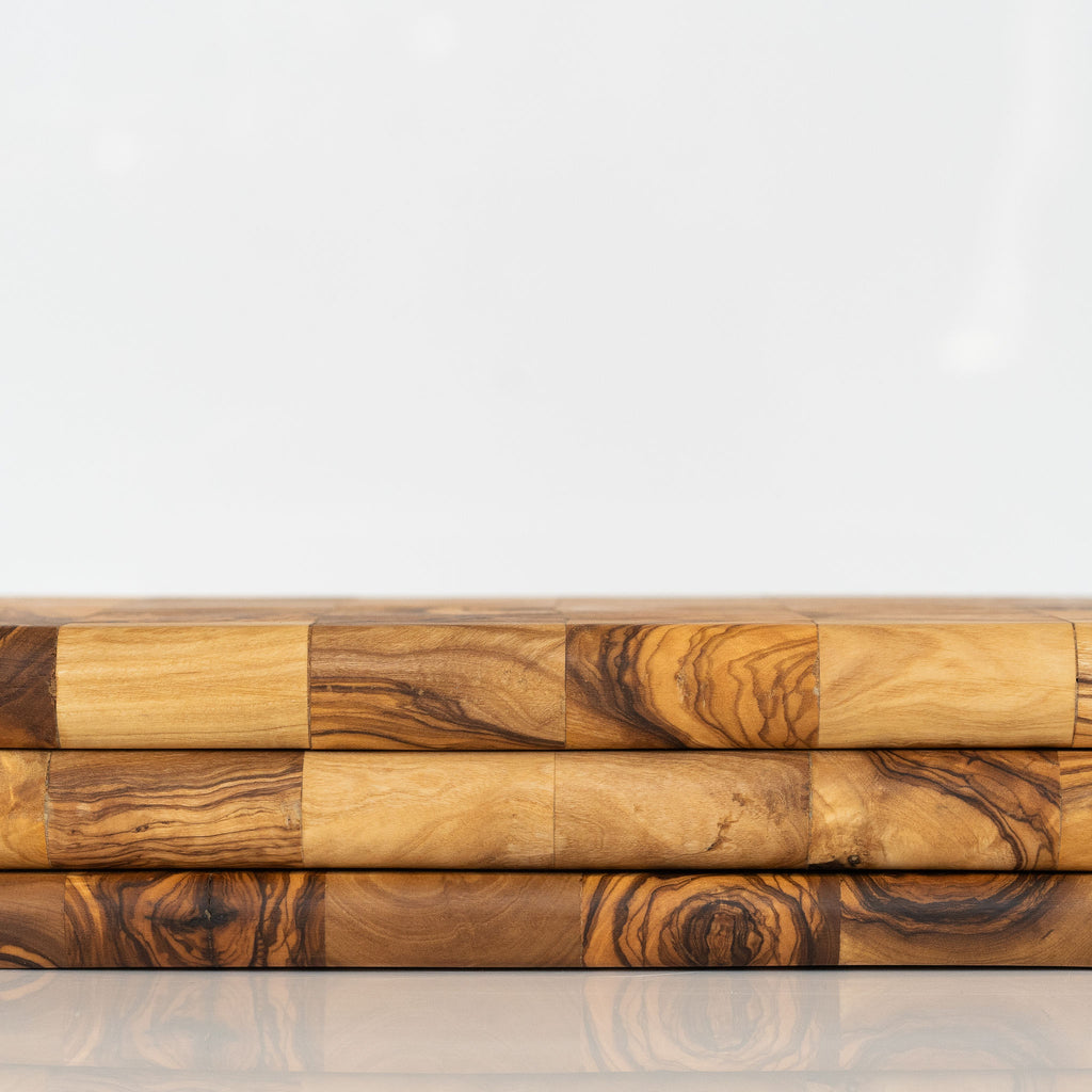 Stack of rectangle olive wood mosaic boards with rounded corners on a white background.