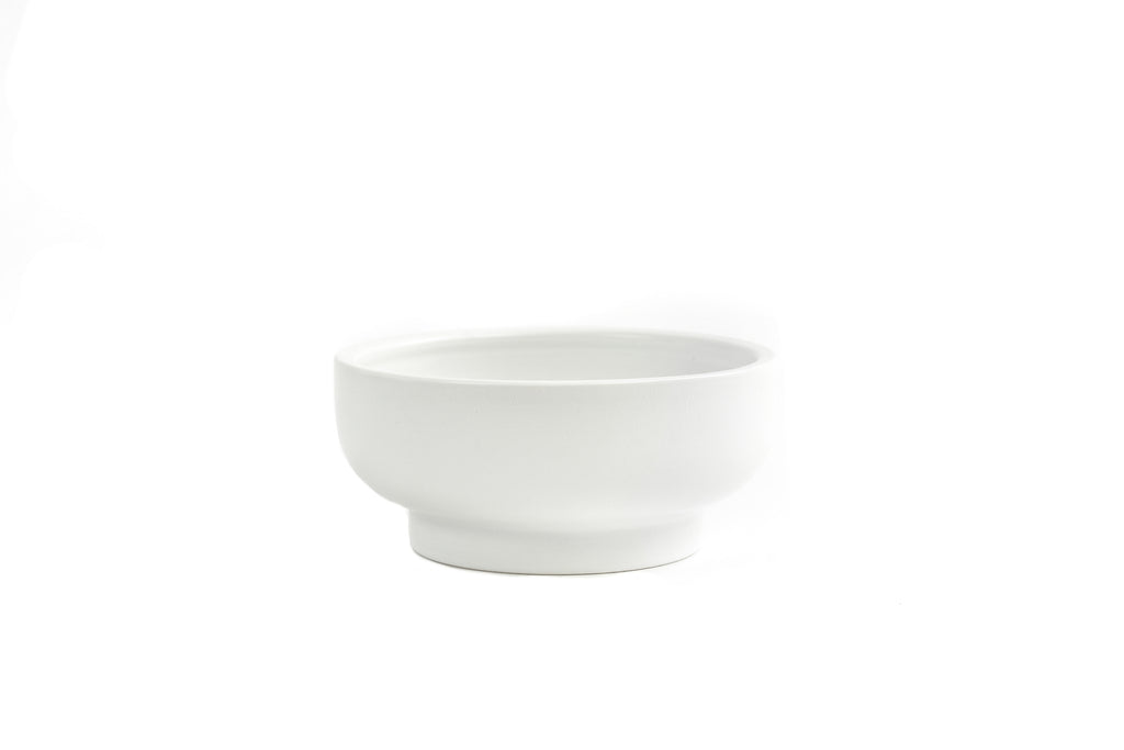 White porcelain bowl with slightly exaggerated pedestal on bottom.