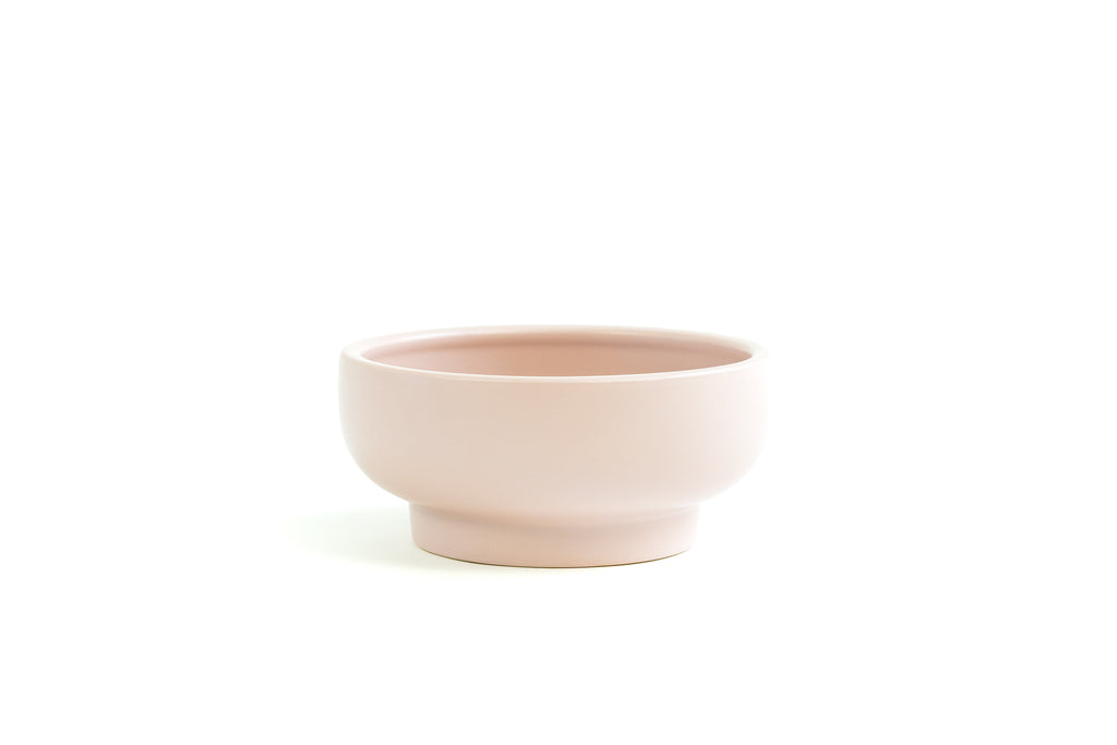 Blush Pink porcelain bowl with slightly exaggerated pedestal on bottom.