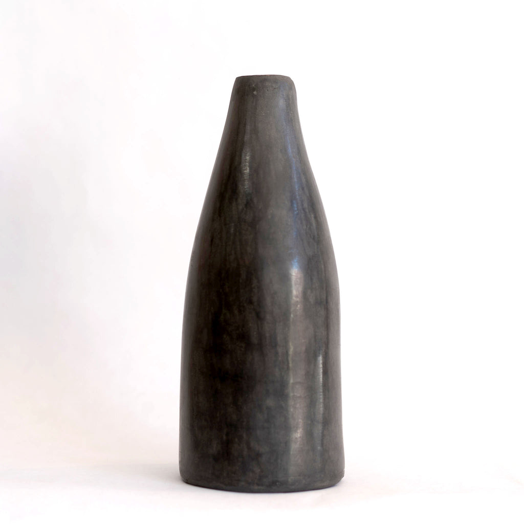 One short slim dark gray Tadelakt vase. White background.