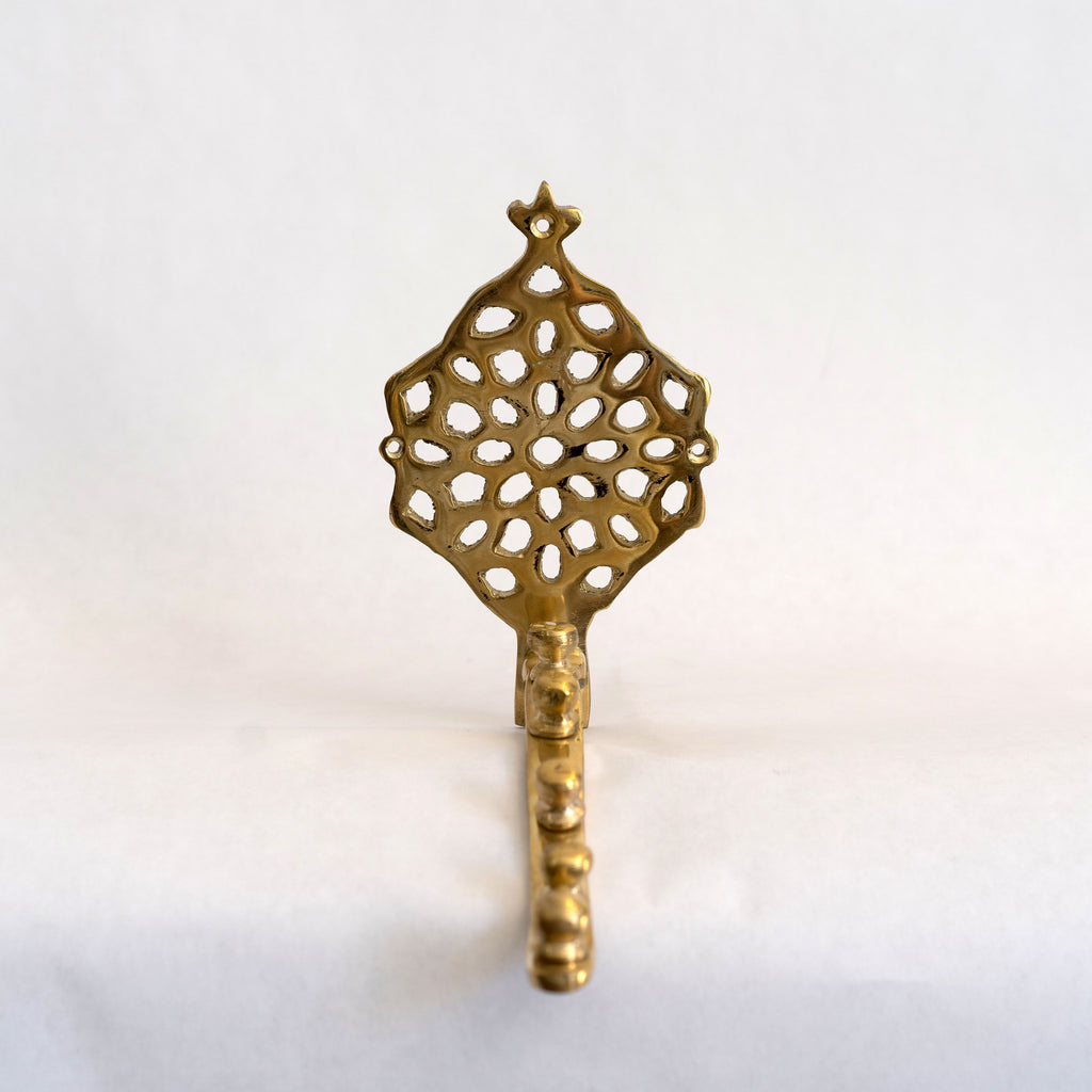 Brass valet hanger with Moroccan metal punch style back. Five knobs along a curved bar.