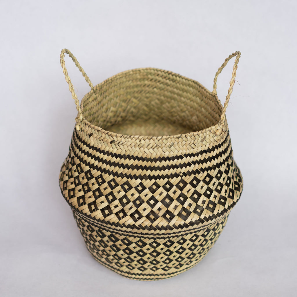 Handwoven palm fiber belly basket in traditional Oaxacan designs. Tan and black alternating small diamonds with contrasting dots inside each diamond. Three black stripes at the middle and at the top and bottom edge. Interior of basket is natural tan. Gray background.