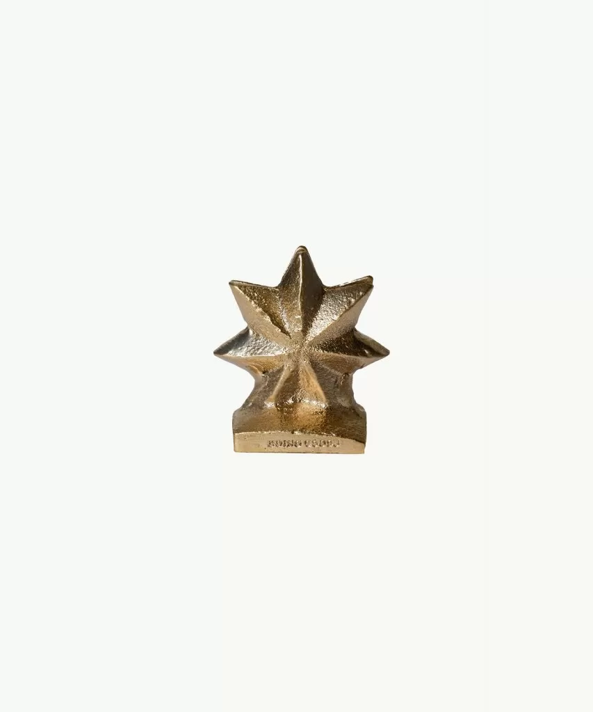 Recycled brass card holder in the shape of a 3D 7-pointed star with flat base sitting against a white background.