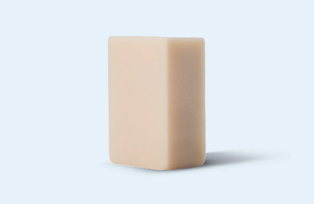 A creamy shave bar sits on a light gray background.