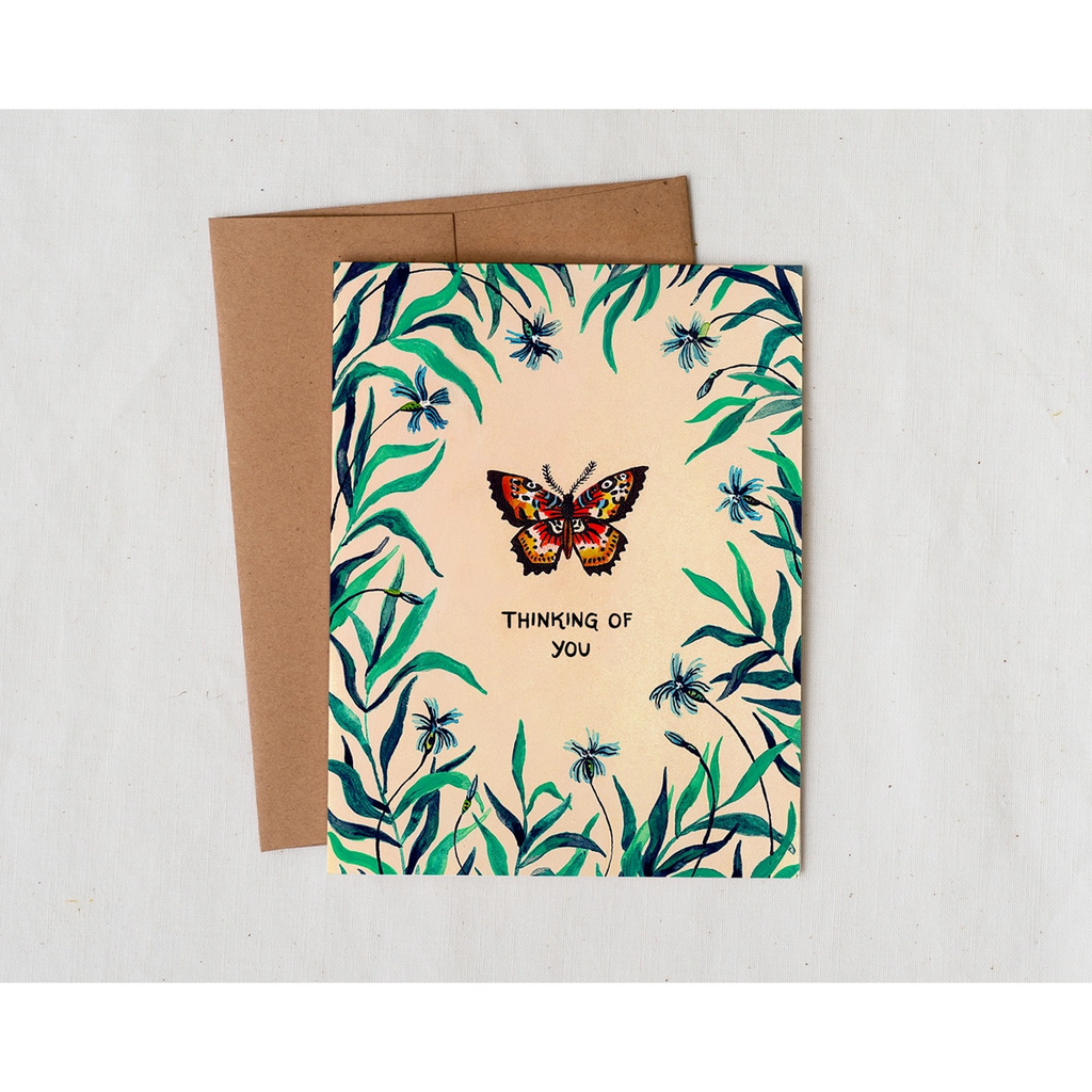 Pale Yellow Greeting card and kraft envelope set. Card features a painted illustration of vines + flower border with a butterfly in the center. Text says 'Thinking of you.'