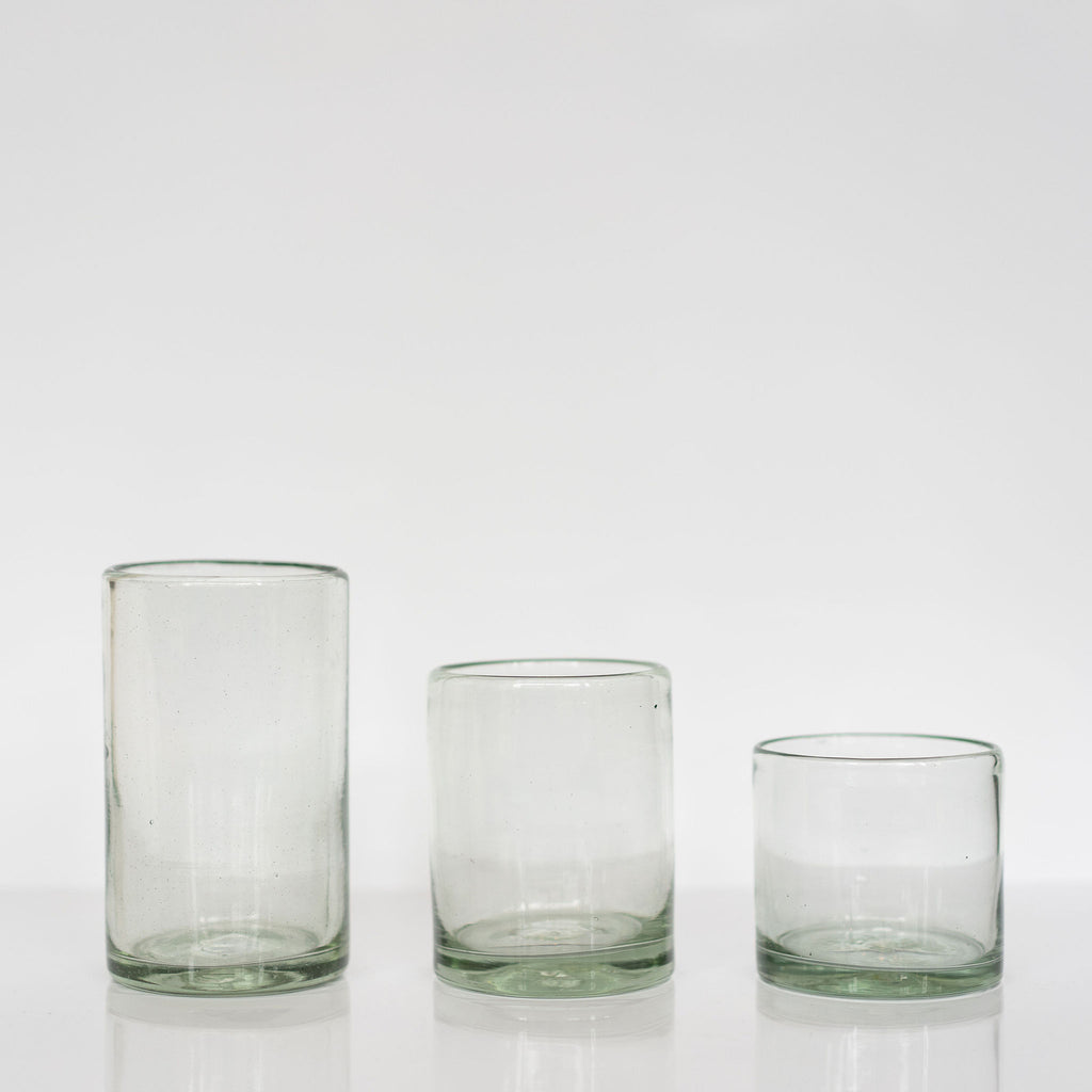 Group of three handblown tumblers in three sizes on white background.