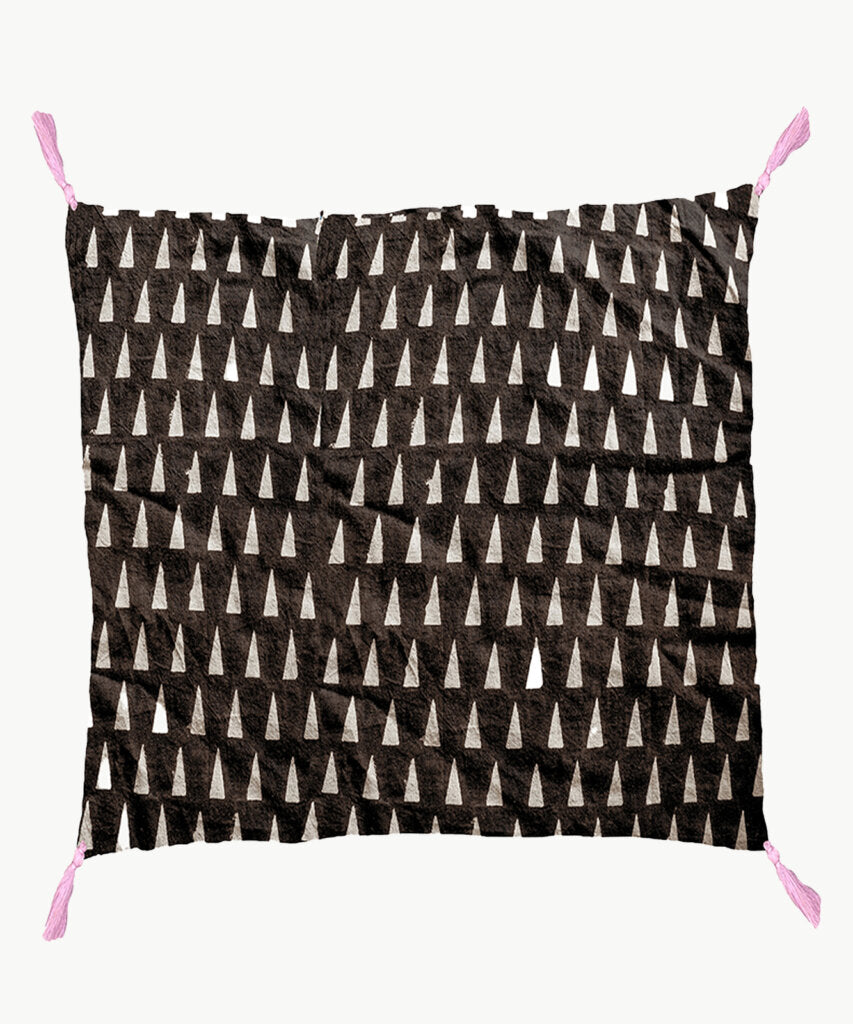 One side of reversible pillow  is brown background with cream triangle print. 