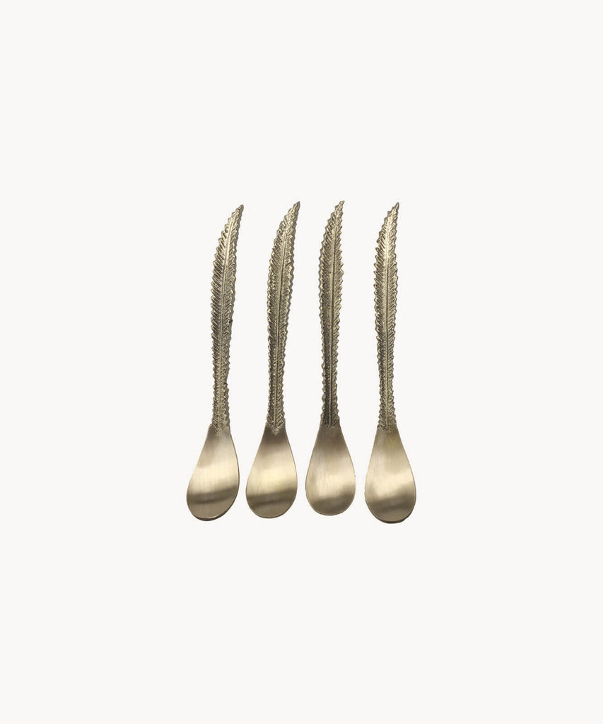 Set of four small brass feather spoons. White background.